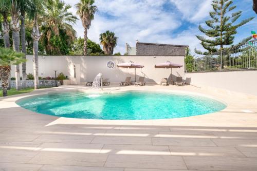 a swimming pool with a fountain in a yard at HOLIDAYS ALBA in Catania