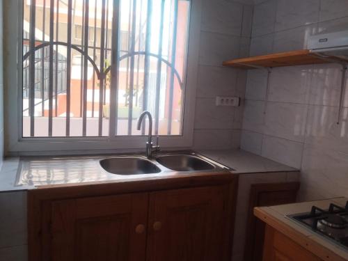 a kitchen with a sink and a window at Auberge de l'hippocampe in Moroni