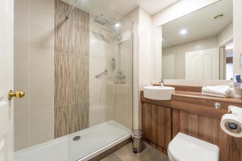 a bathroom with a tub and a sink and a toilet at Corr's Corner Hotel in Newtownabbey