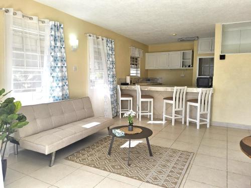 a living room and kitchen with a couch and a table at Ocean Bliss Apartments in Christ Church