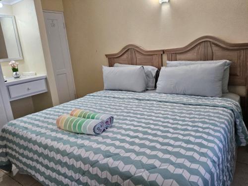 a bed with two pillows sitting on top of it at Ocean Bliss Apartments in Christ Church