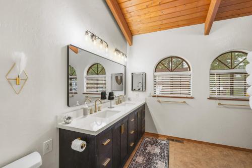 a bathroom with a sink and two mirrors at Spacious Flagstaff A-Frame Casita Getaway in Flagstaff