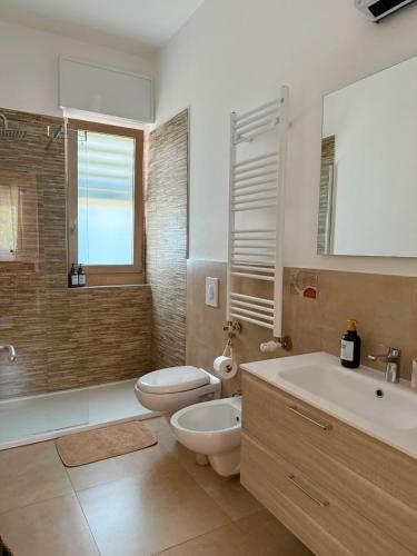 a bathroom with a toilet and a sink and a tub at Violahouse in Bari