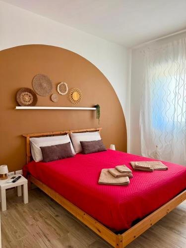 a bedroom with a large red bed with towels on it at Violahouse in Bari