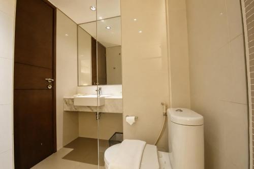 a bathroom with a toilet and a sink and a mirror at Soll Marina Hotel Serpong in Serpong