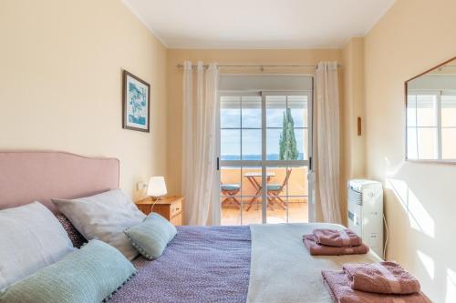 a bedroom with a bed with a view of the ocean at Blue Emi Altea Hills in Altea la Vieja