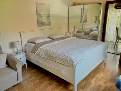 a bedroom with a white bed and a chair at Apartments Lucy in Milna