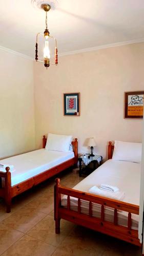 a bedroom with two beds and a chandelier at Grapes and Roses in Igoumenitsa
