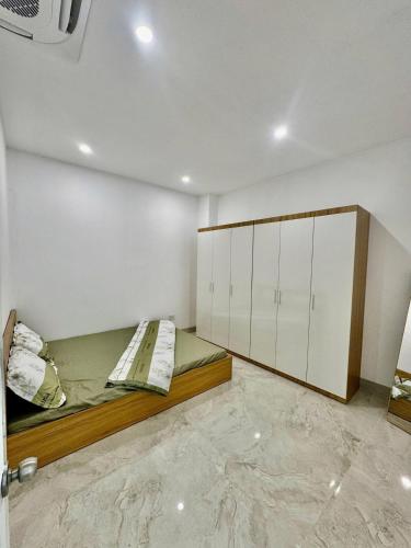 a bedroom with a bed and white cabinets at Lumina Haven in Thượng Lôi