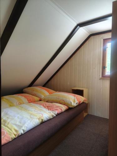 a bed in a room with a attic at Chata Vanessa in Stránske