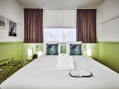 a bedroom with a large bed with towels on it at Mercure Paris Orly Airport in Orly