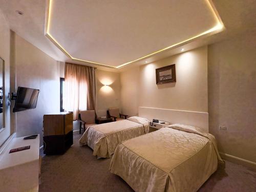 a hotel room with two beds and a television at Beirut Hotel Cairo in Cairo