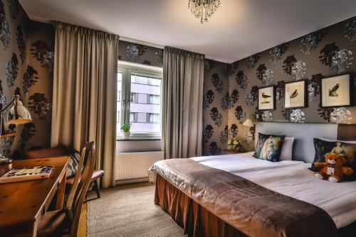 a bedroom with a bed and a desk and a window at Corner Hotel in Stockholm