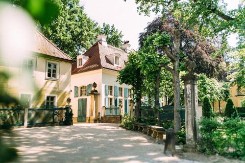 ein großes Haus mit Bänken davor in der Unterkunft Hotel Villa Sorgenfrei & Restaurant Atelier Sanssouci in Dresden