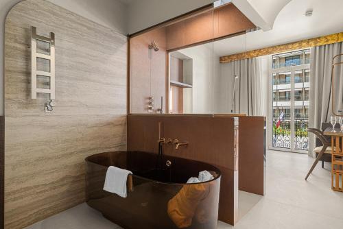 a bathroom with a tub in the middle of a room at Naomi Cannes in Cannes