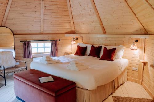 a bedroom with a large bed in a wooden room at Caerketton Cabin in Kirknewton