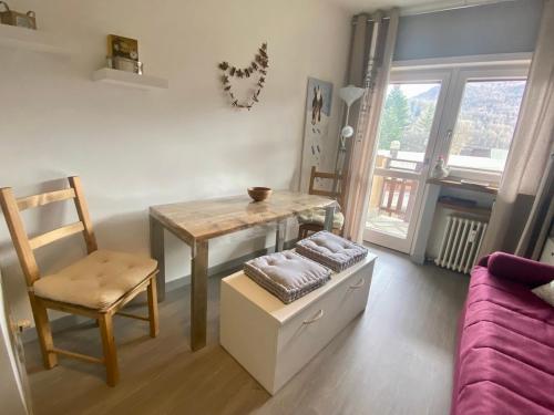 a living room with a table and a chair at Bright and silent studio in Bardonecchia centre in Bardonecchia