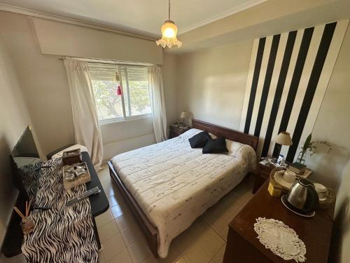 a bedroom with a bed and a table and a window at Casa tranquila y segura in Santa Fe
