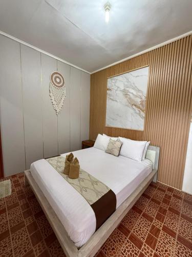 a bedroom with a large bed with two shoes on it at Chika House in Gili Trawangan
