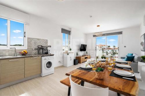 a kitchen and living room with a wooden table and a dining room at Apartment El Breeze in Paralimni