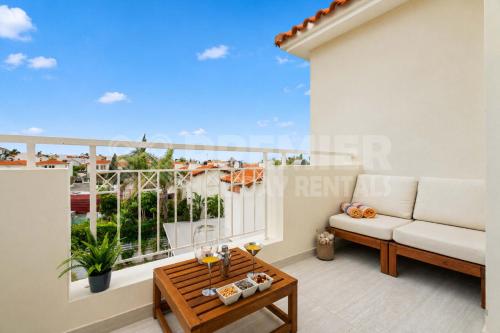 a room with a balcony with a couch and a table at Apartment El Breeze in Paralimni