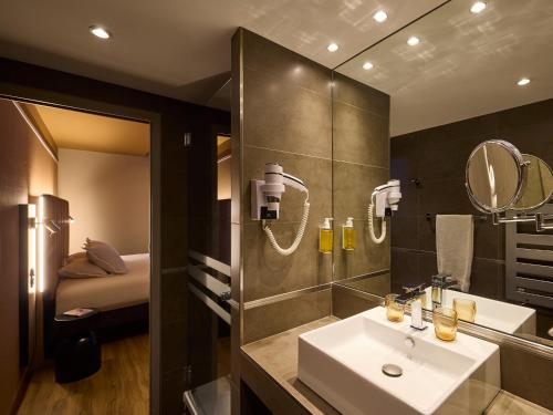 a bathroom with a sink and a mirror at You Hotel de France Valence - Handwritten Collection in Valence