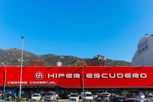 a red building with cars parked in a parking lot at Hotel Nacional in La Jonquera