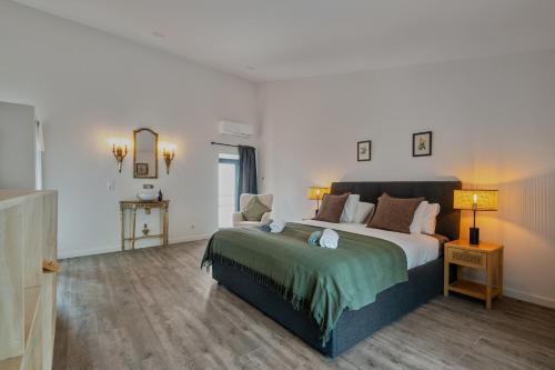 a bedroom with a large bed and a table at Pied-a-Terre Tomar in Tomar