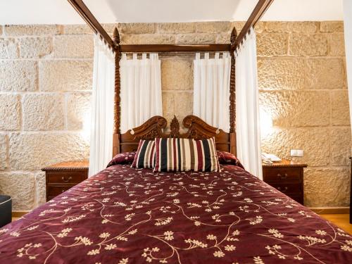 a bedroom with a bed with a wooden canopy at Hotel Boa Vila in Pontevedra