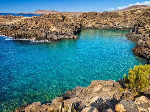 a large pool of blue water in a rocky beach at Primavera Pool Paradise in Arona
