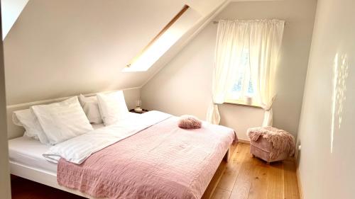 a bedroom with a bed with a pink blanket at Jaani Mardi Puhkemaja in Sooaluse