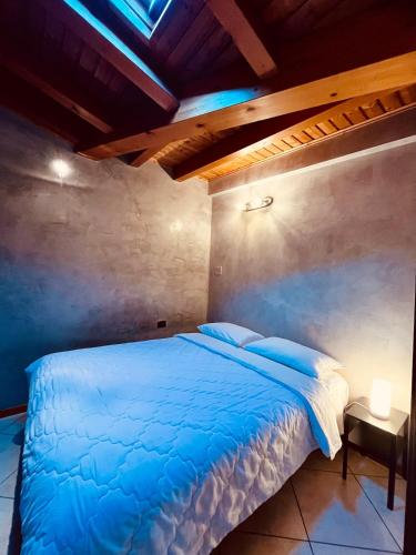a bedroom with a blue bed and a wooden ceiling at BEddy & Breakfast - Station Loft in Seregno