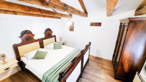 a bedroom with a bed with a wooden headboard at Villa Nostalgia - with private heated pool, jacuzzi and sauna in Koper