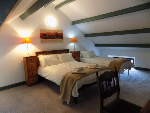 a bedroom with two beds in a room with beams at The Old Creamery Ventry in Ventry