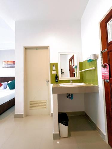 a bathroom with a sink and a mirror at Kata Beachwalk Hotel and Bungalows in Kata Beach
