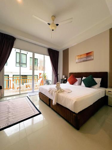 a bedroom with a large bed and a large window at Kata Beachwalk Hotel and Bungalows in Kata Beach