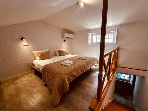 a bedroom with a bed with two towels on it at Casa Jardim in Porto