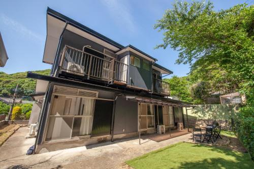 a house with a balcony and a yard at Kokura Family House, 10 Min to Station, 2 Parking, 4 Bed Room in Kitakyushu
