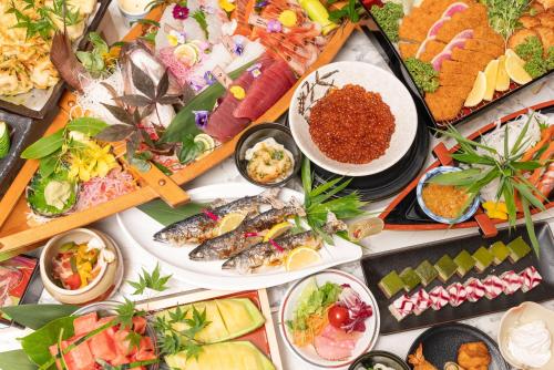 a table filled with different types of food on plates at Livemax Resort Hachimantai Forest in Hachimantai