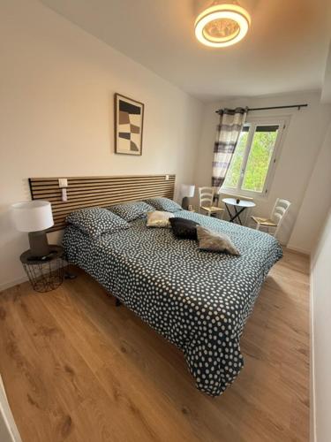 a bedroom with a bed with a black and white comforter at la Pause Pyrénées in Maubourguet
