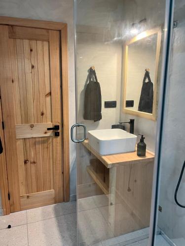 a bathroom with a sink and a mirror and a door at Casa do Encanto in Terra Alta