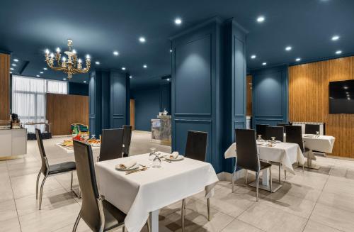 a dining room with tables and chairs and a chandelier at Hotel Regina in Caserta