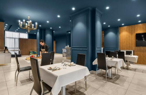 a person standing in a restaurant with tables and chairs at Hotel Regina in Caserta