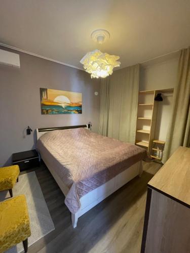 a bedroom with a bed and a chandelier at MonJa puhkemaja in Marathokampos