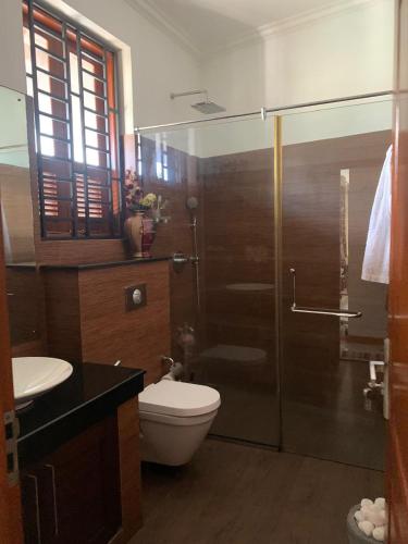 a bathroom with a toilet and a glass shower at Deepa Thamel House in Cotta Road Railroad Station