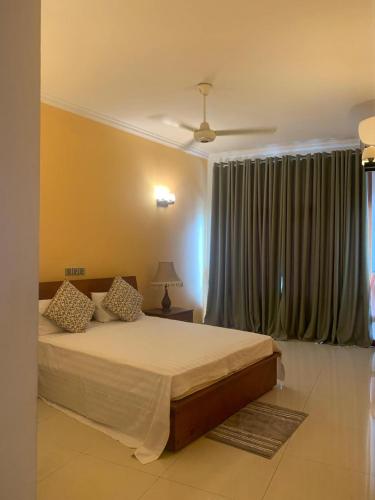 a bedroom with a bed and a large window at Deepa Thamel House in Cotta Road Railroad Station