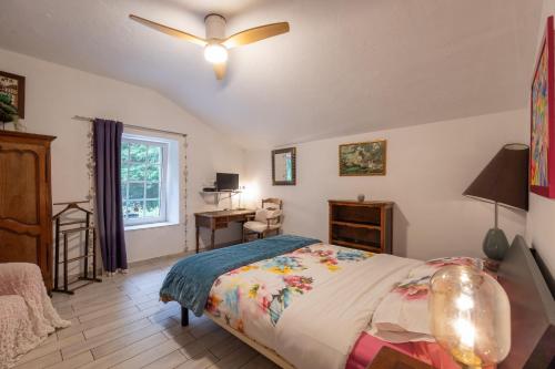 a bedroom with a bed and a ceiling fan at Gîte Du Ruisseau avec spa et pêche in Épinal