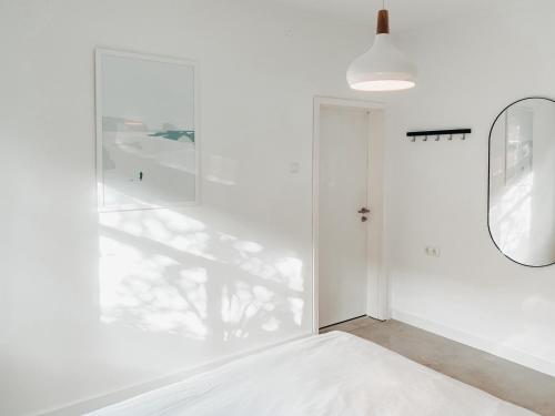 a hallway with a mirror and a white wall at Casa Bonita in Heikendorf