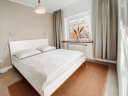 a bedroom with a white bed and a window at Casa Bonita in Heikendorf