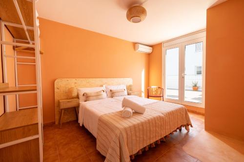 a bedroom with a bed and a large window at The Loft House Ibiza in Santa Eularia des Riu
